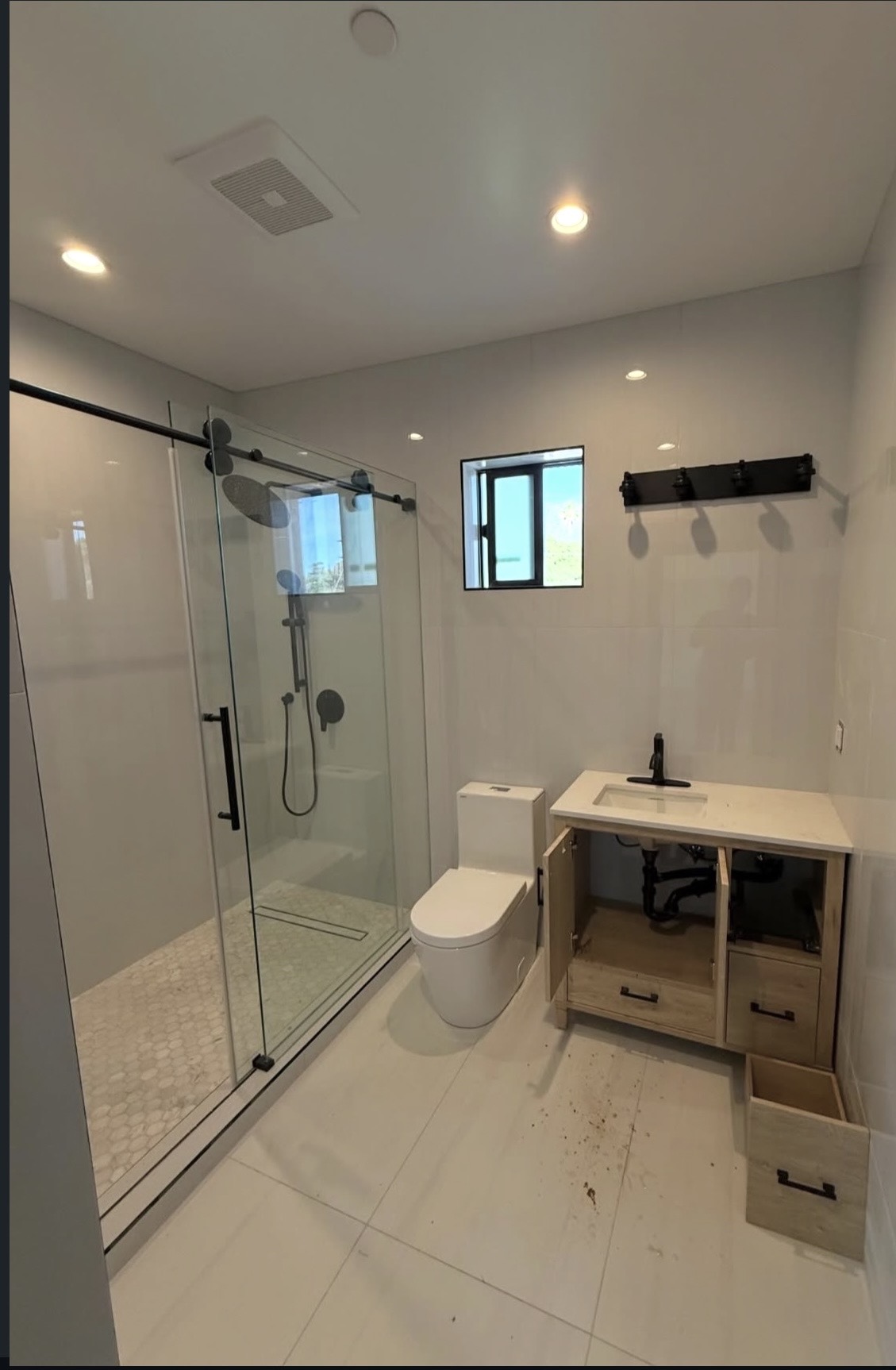 Finished bathroom by G Keystone Inc. with glass walk-in shower, matte black fixtures and quartz-top vanity